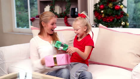 Mother-and-daughter-exchanging-gifts-at-christmas