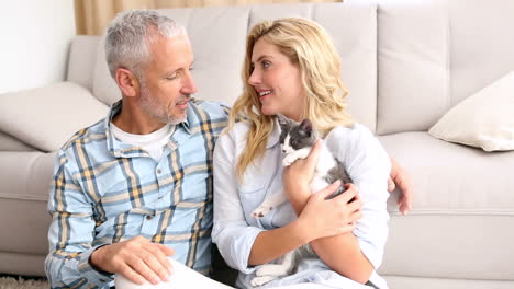 Happy-couple-with-their-kitten-on-the-floor