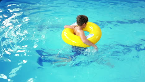 Cute-little-boy-using-inflatable-ring-in-the-pool