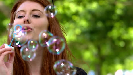 Pretty-redhead-blowing-bubbles-in-the-park
