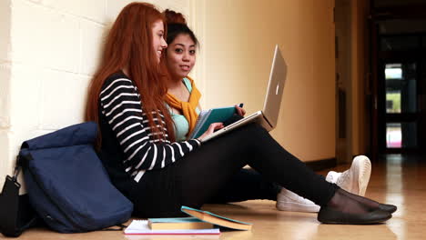 Bonitos-Estudiantes-Charlando-En-El-Pasillo-Usando-Una-Computadora-Portátil.