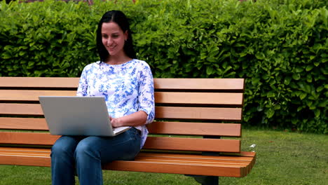 Frau-Sitzt-Auf-Parkbank-Mit-Laptop