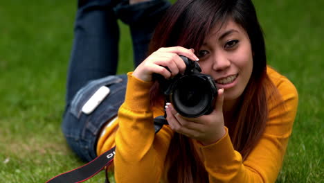 Pretty-asian-girl-taking-a-photo-on-the-grass