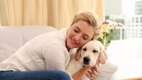 Happy-blonde-playing-with-puppy-on-the-couch