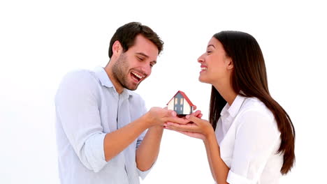Attractive-young-couple-holding-mini-house