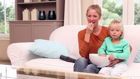 Cute-little-girl-watching-tv-with-her-mother