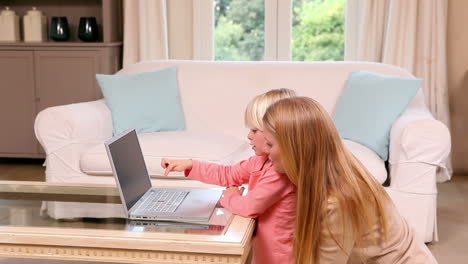 Cute-little-girl-using-laptop-with-mother-
