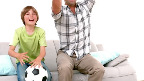 In-Zeitlupe-Glücklicher-Vater-Und-Sohn-Mit-Fußball-Vor-Dem-Fernseher