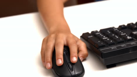 Cute-pupil-using-computer-in-school