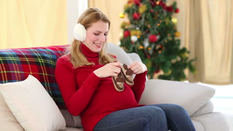 Festive-pregnant-blonde-holding-baby-booties