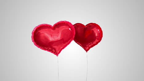 Heart-balloons-floating-against-grey-background