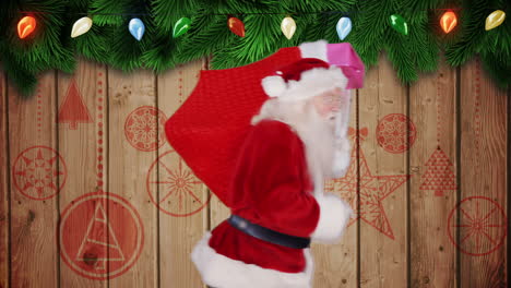 Santa-carrying-sack-of-gifts-against-festive-wooden-background