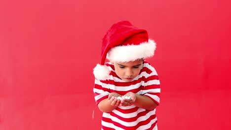 Cute-festive-boy-blowing-confetti-over-hands