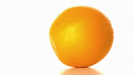 Naranja-Girando-Sobre-Una-Superficie-Blanca
