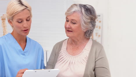 Nurse-talking-with-elderly-patient-in-office