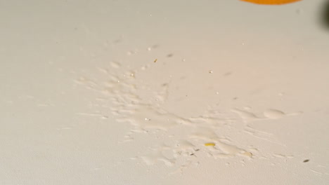 Orange-falling-and-bouncing-on-white-surface