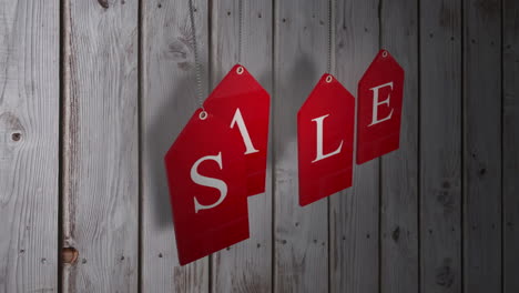 Red-sale-tags-hanging-against-wood