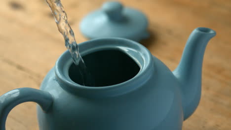 Hot-water-pouring-into-blue-teapot