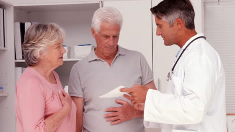 Doctor-explaining-prescription-to-elderly-couple