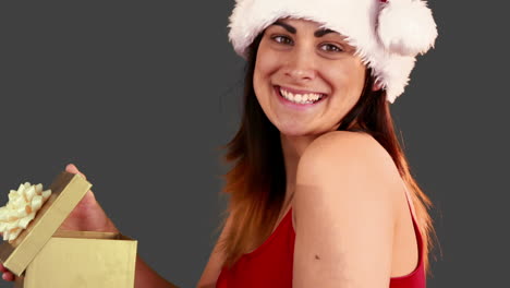 Festive-brunette-opening-a-christmas-gift