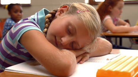 Schoolchild-napping-on-notepad-at-school