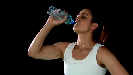 Fit-brunette-catching-her-breath-and-drinking-water
