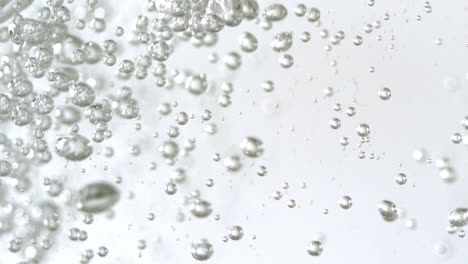 Bubbles-rising-in-water-on-white-background