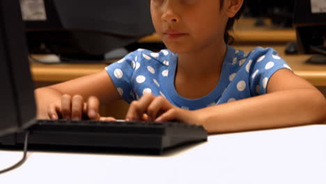 Cute-pupil-using-computer-in-school