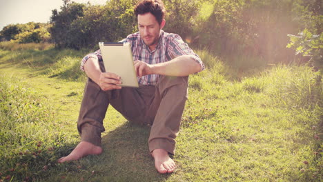 Young-man-using-tablet-in-the-countryside