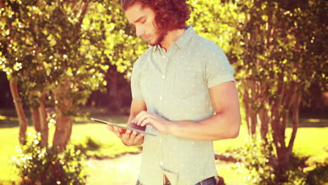 In-high-quality-4k-format-young-man-using-tablet-in-the-park