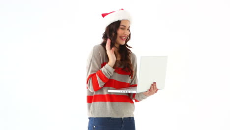 Pretty-festive-brunette-chatting-with-someone-online-on-laptop