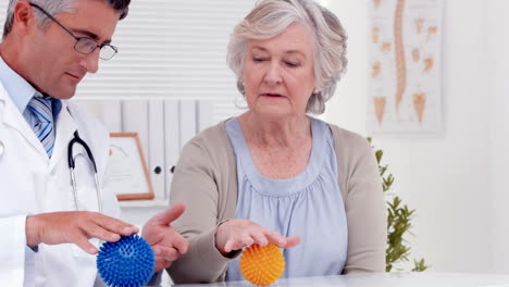 Arzt-Zeigt-Patienten,-Wie-Man-Verletzte-Hand-Trainiert