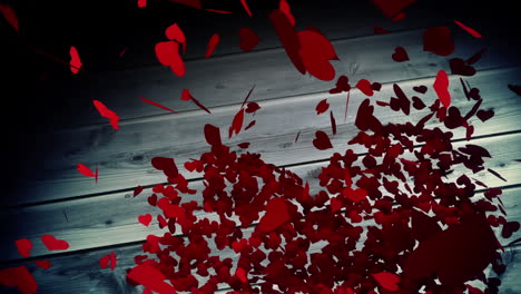 Red-hearts-falling-on-wooden-surface