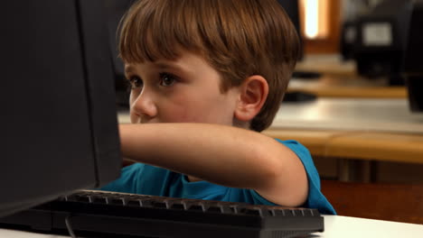 Cute-pupil-using-computer-in-school