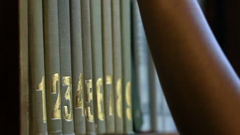 Student-picking-a-book-from-shelf-in-library