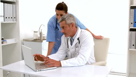 In-slow-motion-doctor-using-computer-keyboard-at-desk