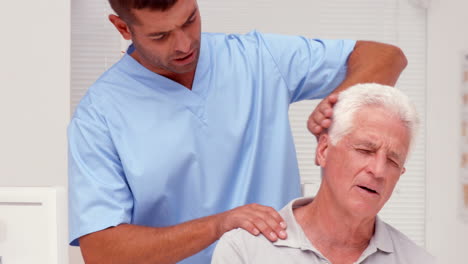 Physiotherapist-examining-shoulders-of-patient