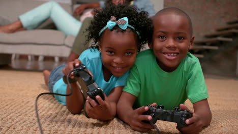 Geschwister-Spielen-Videospiele-Auf-Dem-Boden,-Während-Die-Eltern-Zuschauen