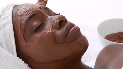 Masseuse-applying-product-on-her-client-face-