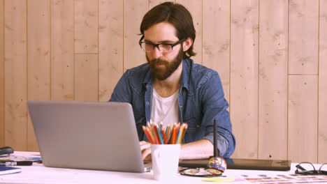 Casual-worker-at-his-desk-using-laptop
