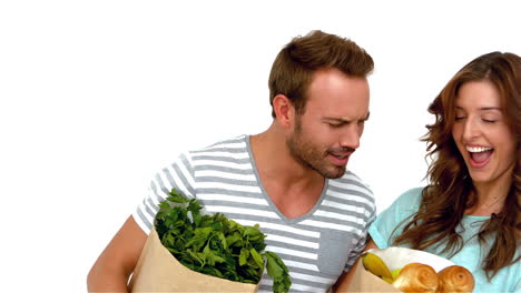 Happy-couple-holding-grocery-bags