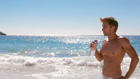 Hombre-Atractivo-Bebiendo-Agua-En-La-Playa