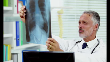 Portrait-of-a-smiling-doctor-holding-a-x-ray
