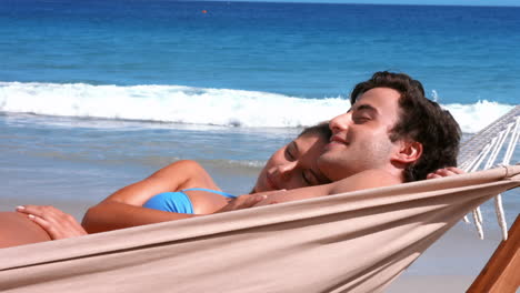 Happy-couple-relaxing-in-hammock-on-beach