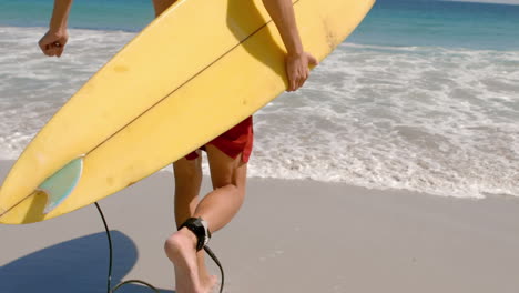 Handsome-man-running-in-the-water-with-surfboard