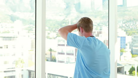 Thoughtful-doctor-looking-through-windows-