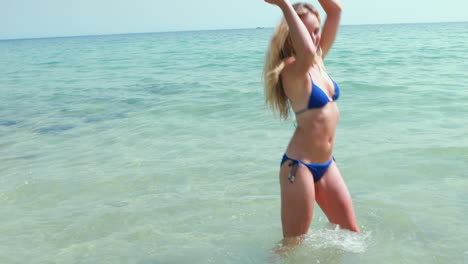 Smiling-blonde-woman-playing-in-the-ocean