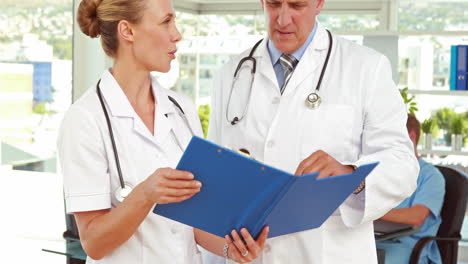 Two-doctors-looking-at-clipboard-in-medical-office
