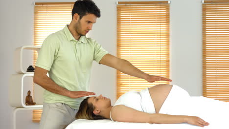 Therapist-performing-reiki-on-patient