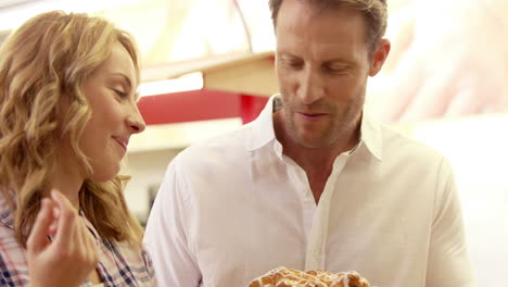 Young-happy-couple-looking-at-cakes